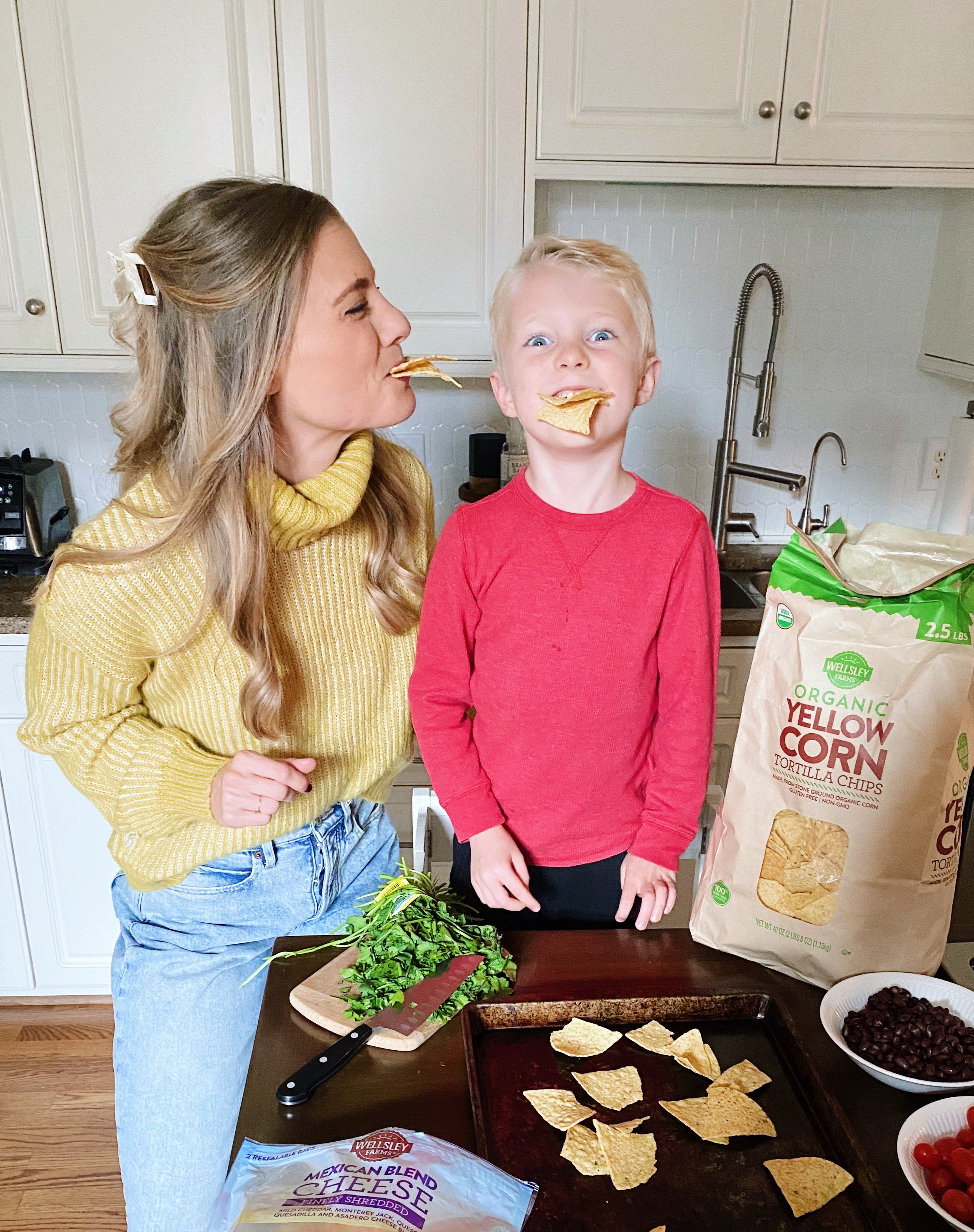 Mom and son enjoying Wellsley Farms Organic Yellow Corn tortillas while making nachos