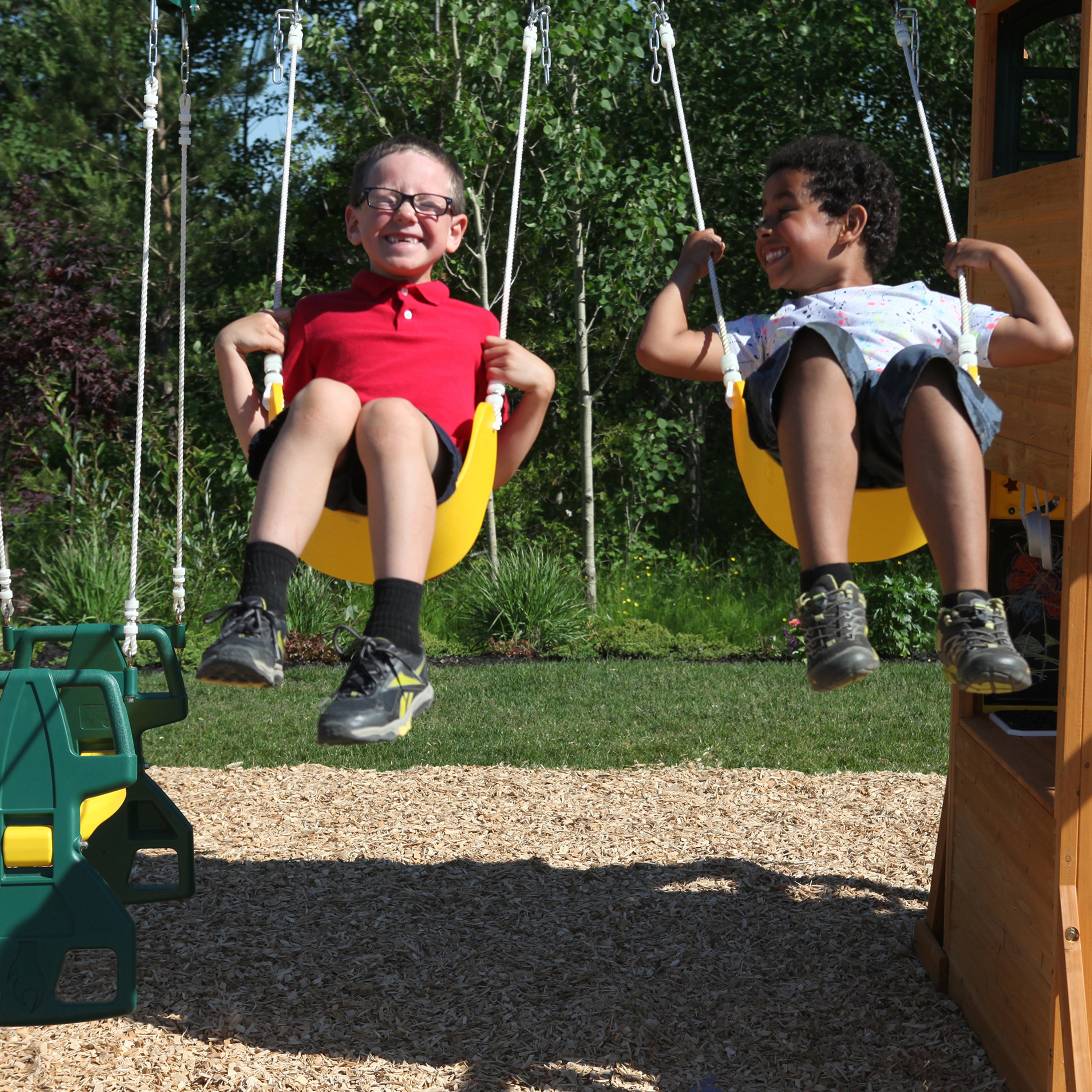 2 boys smiling on swings