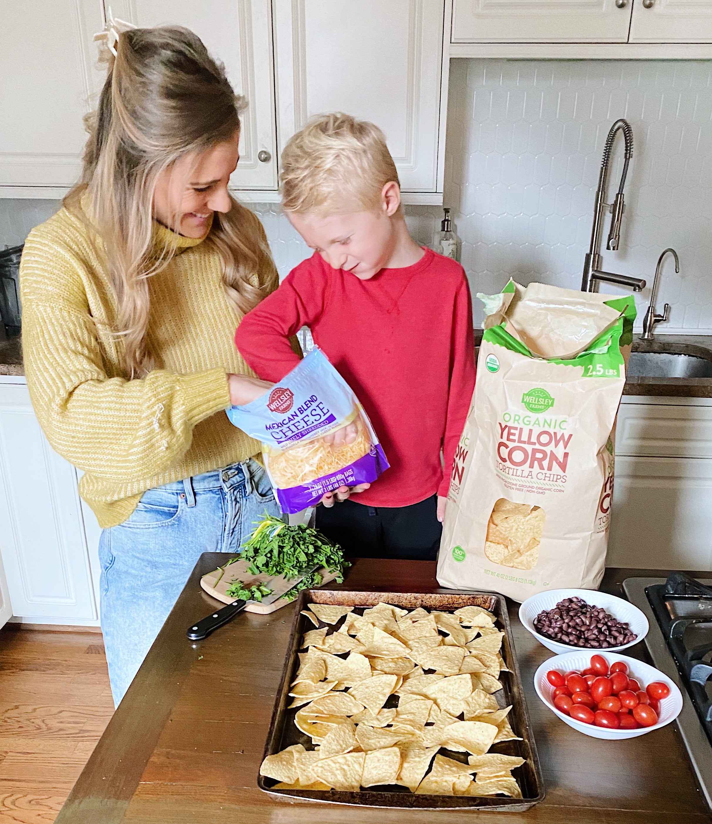 Mom & son adding Wellsley Famrs Mexican cheese to chicken nachos