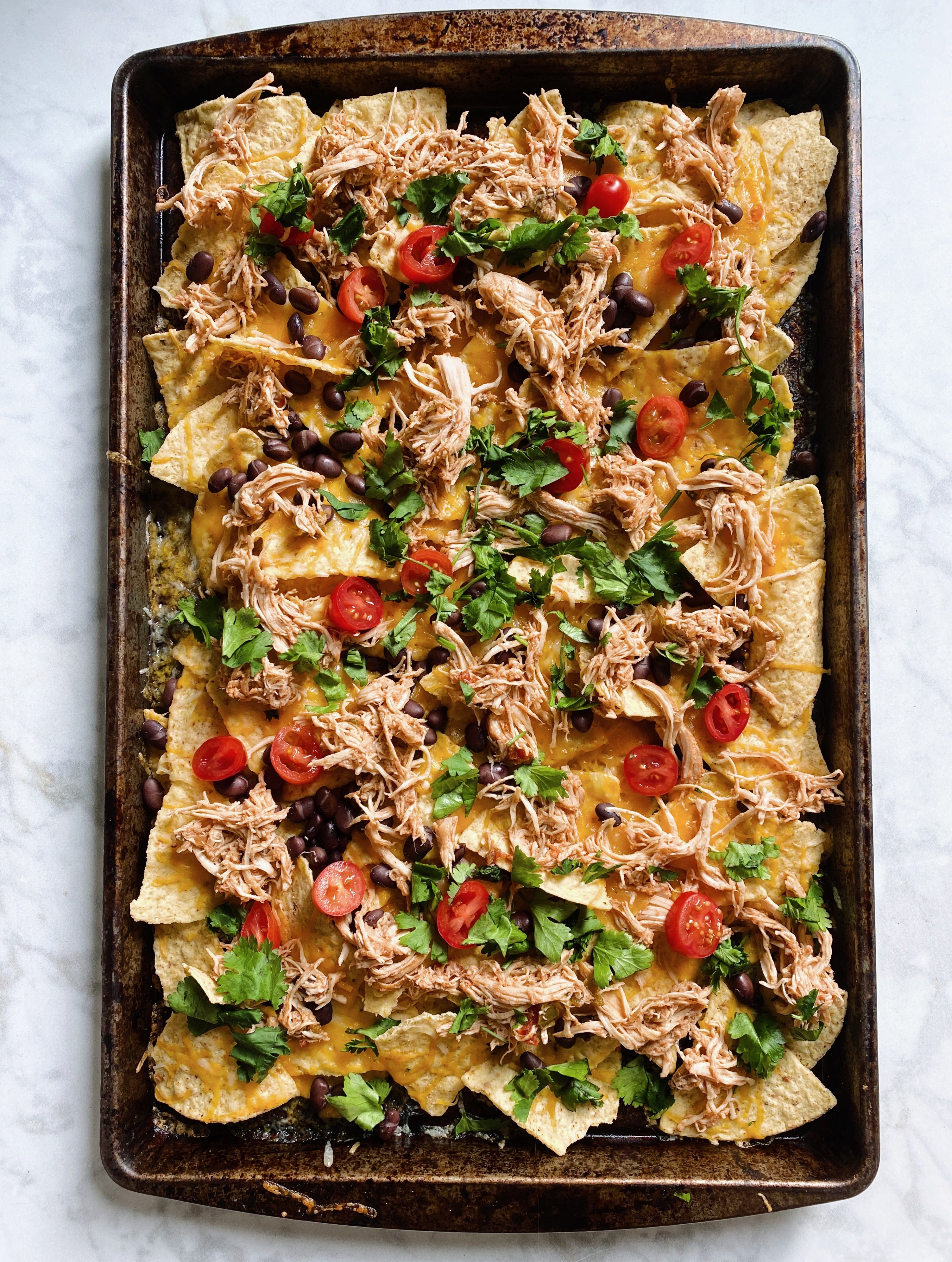 Finished product of Slow Cooker Salsa Chicken Nachos on a pan